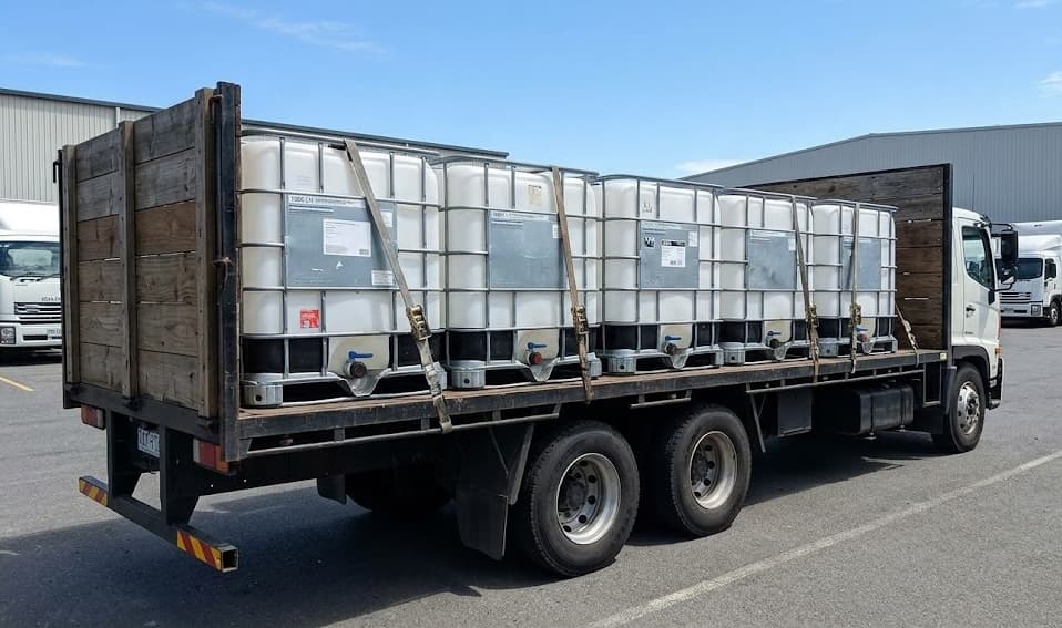 Flatbed truck carrying IBC tanks for delivery